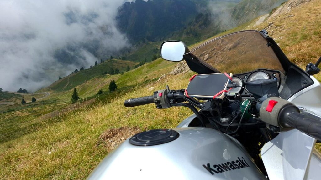 Soporte de móvil con teléfono montado en el manillar de una moto